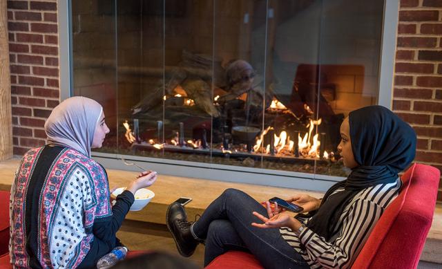 Two students sitting in front of the fire at the Ohio Union