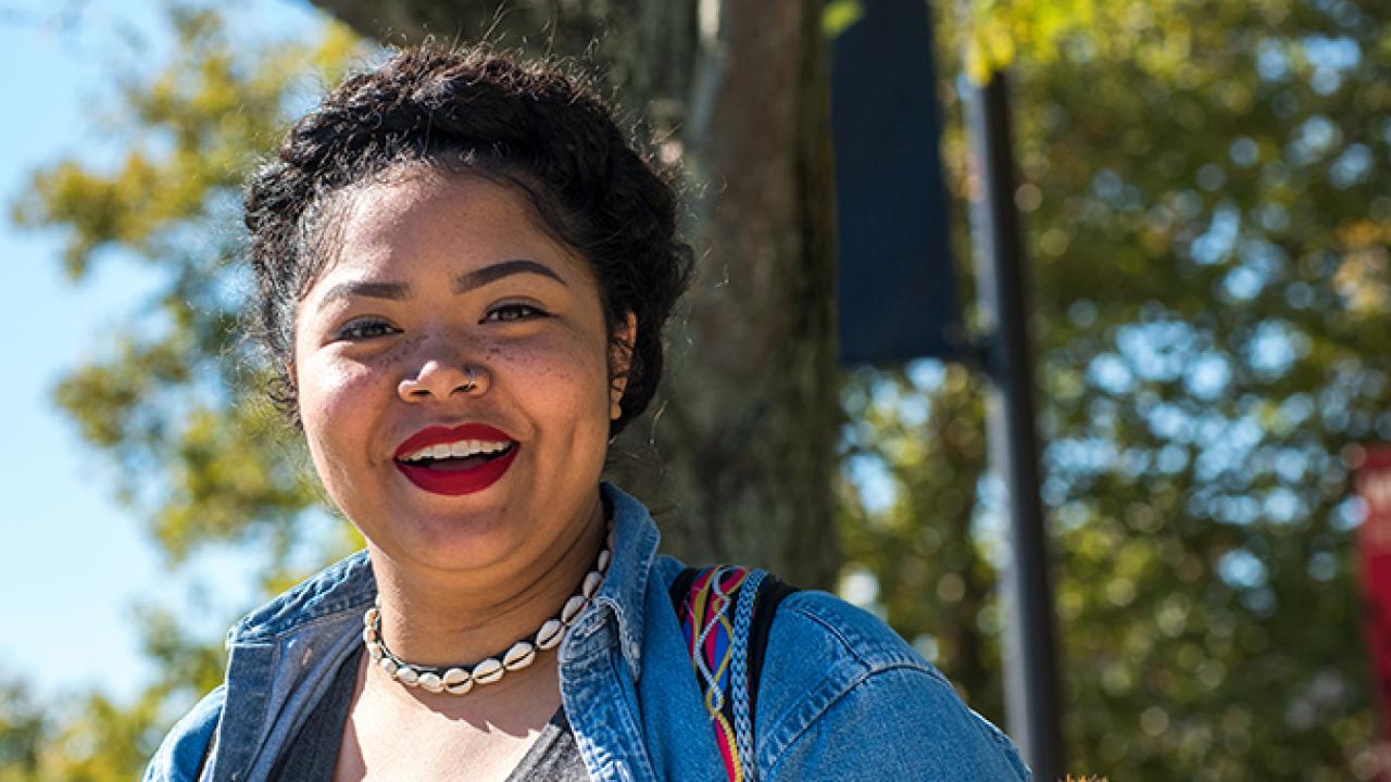 Student on the oval wearing a denim jacket and shell necklace