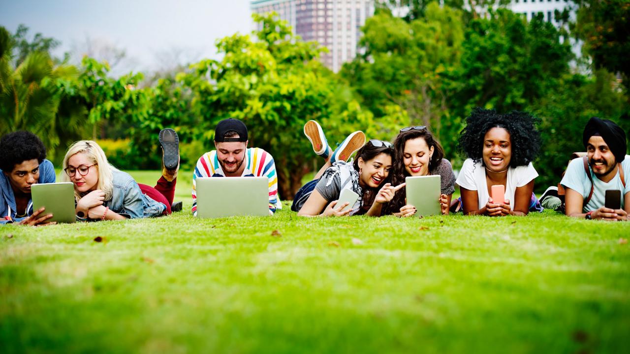 Students outside with electronic devices